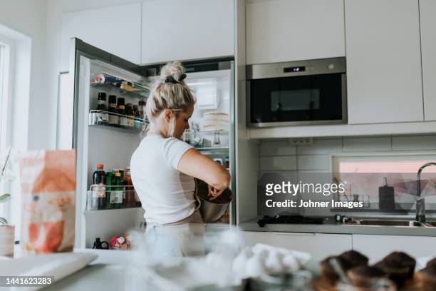 woman baking in kitchen - refrigerator front stock pictures, royalty-free photos & images