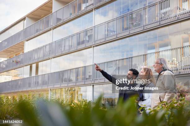men and woman with laptop looking at buildings - architect photos et images de collection