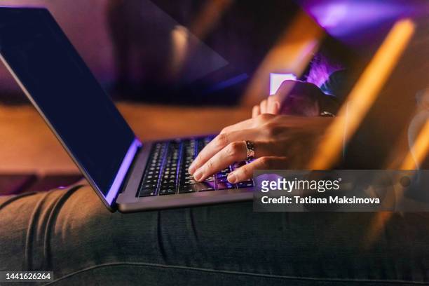 the hands of a girl with rings are typing on a laptop, close-up. glare on the background. - arabic keyboard fotografías e imágenes de stock