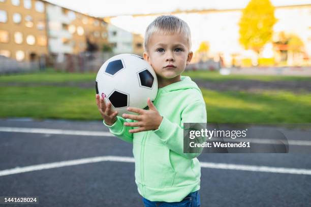 cute boy with soccer ball in sports court - fußball 2 jungs stock-fotos und bilder