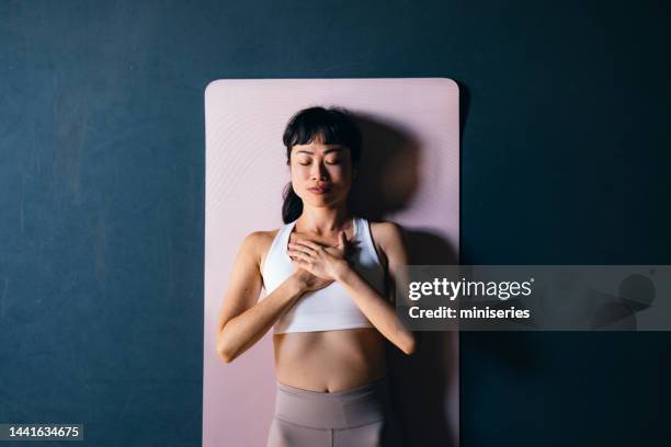 high angle view of beautiful woman doing breathing exercise - savasana stock pictures, royalty-free photos & images