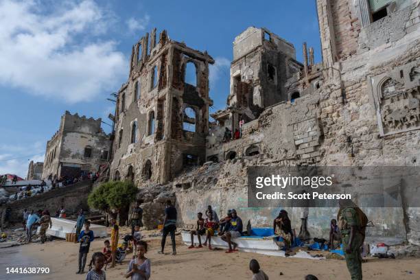 Somalis rest on the beach amid the ruins of the old port and traditional lighthouse, as famine looms over Somalia with an estimated 7.8 million...