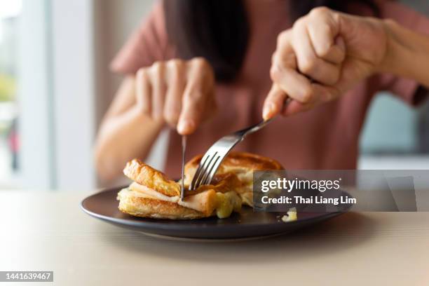 woman enjoying cheese and ham toast close up - grillad sandwich bildbanksfoton och bilder