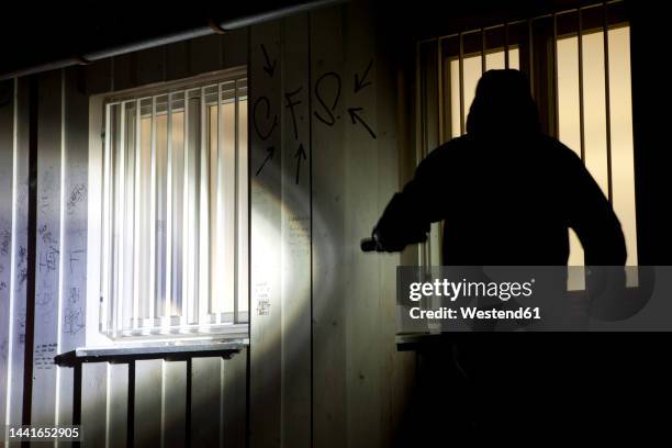 germany, burglar with torch trying to break into house - burglary stock pictures, royalty-free photos & images