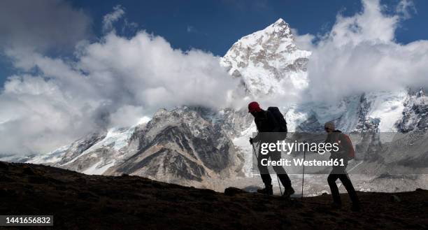 man and woman trekking with mt everest, nuptse and kala patthar in background, himalayas, solo khumbu, nepal - mount everest stock-fotos und bilder