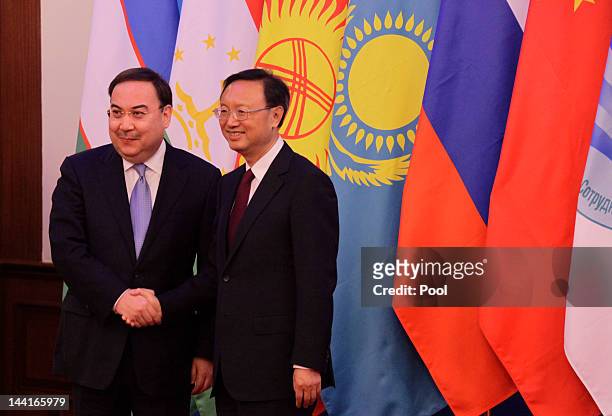 China's Foreign Minister Yang Jiechi shakes hands with Kazakhstan's Foreign Minister Yerzhan Kazykhanov as they arrive for a group photo with Foreign...
