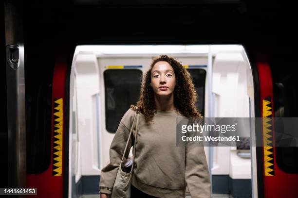 young woman disembarking from train at subway station - gå i land bildbanksfoton och bilder