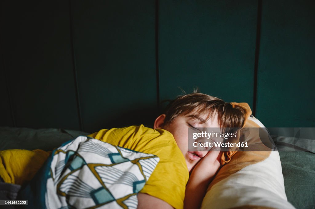 Boy sleeping in bed at home