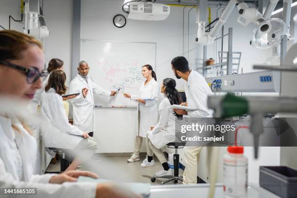 scientists having a meeting - lecturer whiteboard stock pictures, royalty-free photos & images