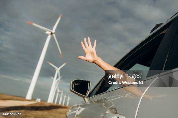 hand of woman out of car window at wind park - autostop stock-fotos und bilder