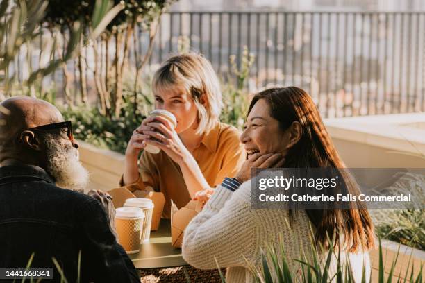 a group of coworkers enjoy an alfresco lunch - breakfast woman stockfoto's en -beelden