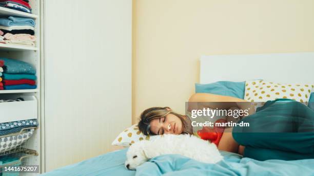 frau mit bauchschmerzen bleibt zu hause - wärmflasche stock-fotos und bilder