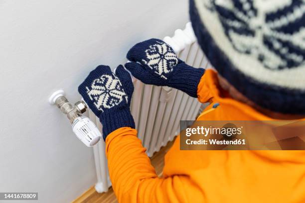 senior man standing with hands on radiator - tumvante bildbanksfoton och bilder