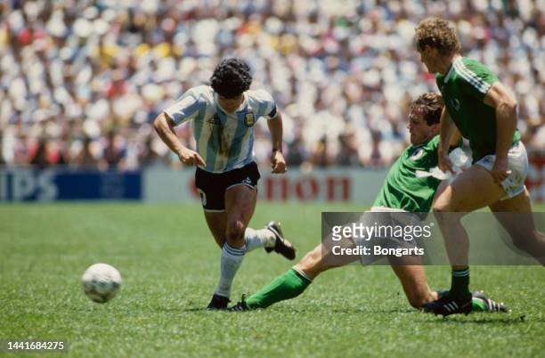 Argentine footballer Diego Maradona under pressure from German footballer Lothar Matthaus and German footballer Hans-Peter Briegel during the final...