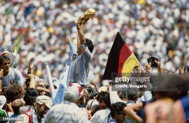 Argentine footballer Diego Maradona lifts the FIFA World Cup trophy following the final of the 1986 FIFA World Cup, held at the Estadio Azteca,...