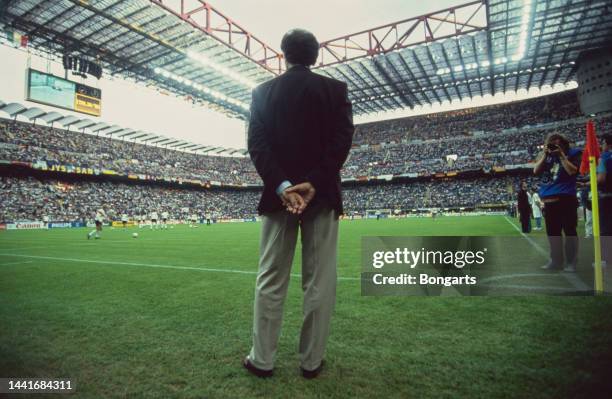 Rear view of German football manager and former footballer Franz Beckenbauer, manager of the West Germany national team, with his hands behind his...