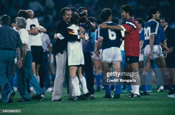 German football manager and former footballer Franz Beckenbauer hugs German footballer Rudi Voller following the final of the 1990 FIFA World Cup,...