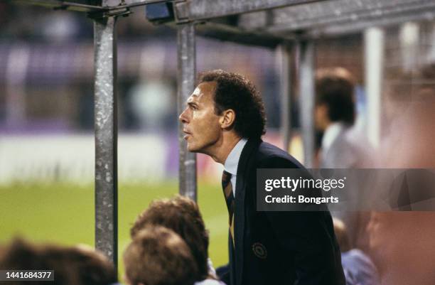 German football manager and former footballer Franz Beckenbauer, manager of the West Germany national team, in the dugout watching the 1990 FIFA...
