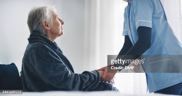 nurse, healthcare and disability with a senior woman patient in a hospital or retirement home with her caregiver. help, support and medical insurance with a mature female and carer in a house - palliative care stock pictures, royalty-free photos & images