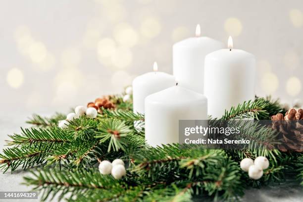four burning white advent candles in advent wreath decoration on light background. - christmas candle foto e immagini stock