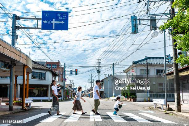 the family is crossing the crosswalk - couple crossing street stock pictures, royalty-free photos & images