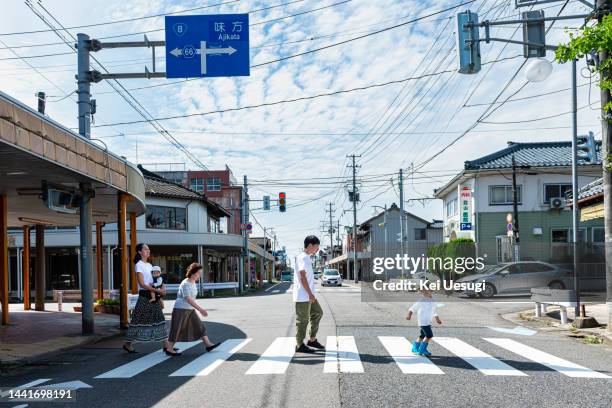 the family is crossing the crosswalk - couple crossing street stock pictures, royalty-free photos & images