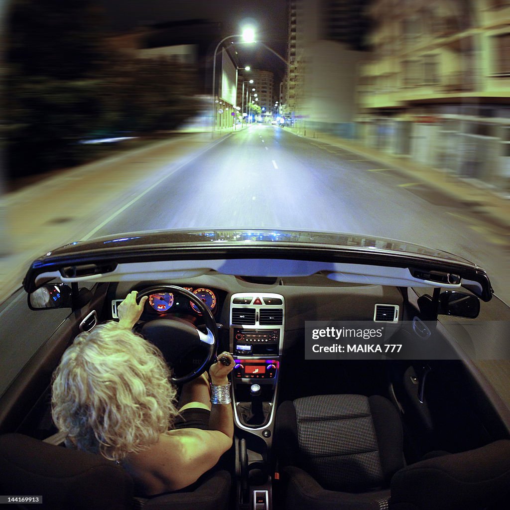 Blonde woman driving at night