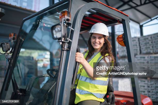 portrait of a female warehouse worker in a forklift. - distribution warehouse stockfoto's en -beelden