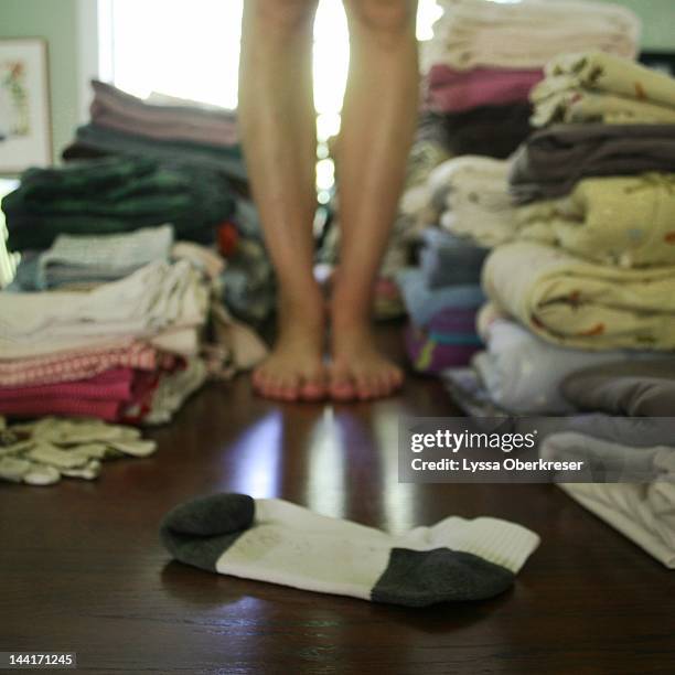 woman standing next to laundry - lost sock stock pictures, royalty-free photos & images