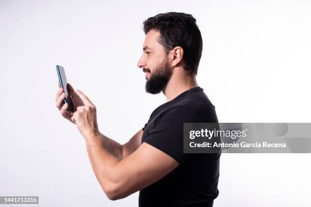 man on white background looking phone - middle eastern male on phone isolated stock pictures, royalty-free photos & images