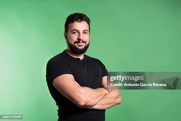 man on studio green backrground smiling and poising - mid adult - fotografias e filmes do acervo