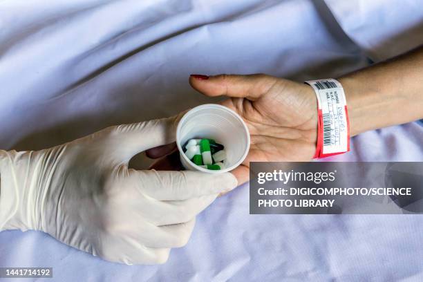 nurse giving a patient a dose of daily medication - hospice stock pictures, royalty-free photos & images