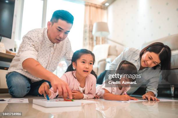 beautiful chinese family smiling ans laughing in the living room - 40 44 ans stock pictures, royalty-free photos & images