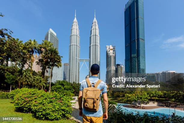 rear view of a man looking at kuala lumpur skyline, malaysia - malaysia skyline stock pictures, royalty-free photos & images