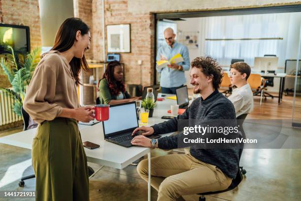 office colleagues having casual discussion in the office - kantoorromance stockfoto's en -beelden