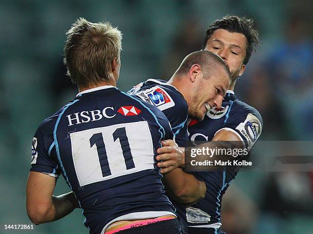 Rob Horne of the Waratahs is congratulated by Adam Ashley-Cooper and Tom Kingston of the Waratahs after scoring a try during the round 12 Super Rugby...