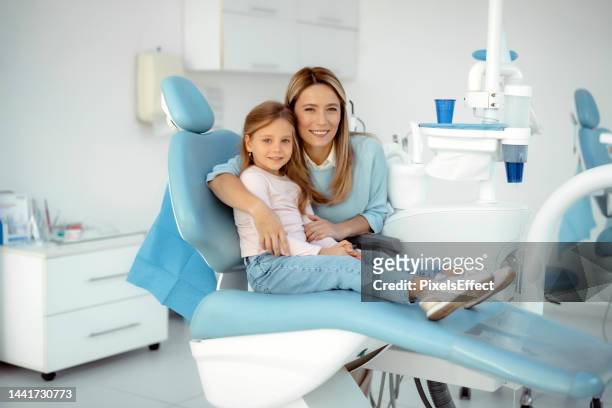 portrait of mother and daughter at dentist office - dentist's chair stock pictures, royalty-free photos & images