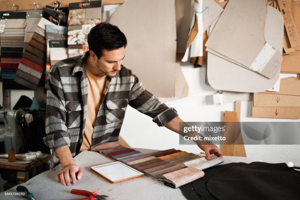 Professional chair maker choosing between materials in his workshop