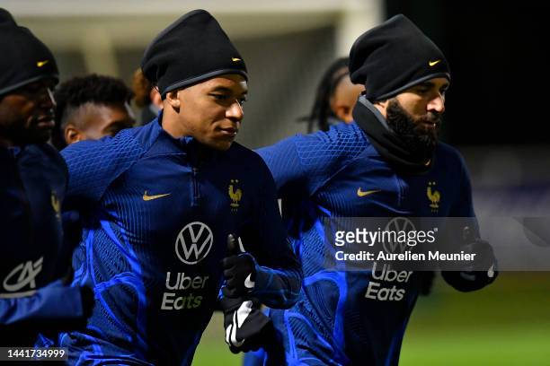 Kylian Mbappe and Karim Benzema warmup during a Team France training session at Centre National du Football on November 15, 2022 in...