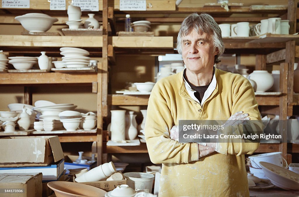 Potter standing proud in front of work.