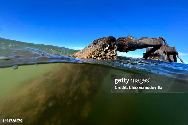 An excavator sits partially submerged in the rising waters of the Chesapeake Bay on November 12, 2022 on Holland Island, Maryland. The excavator was...