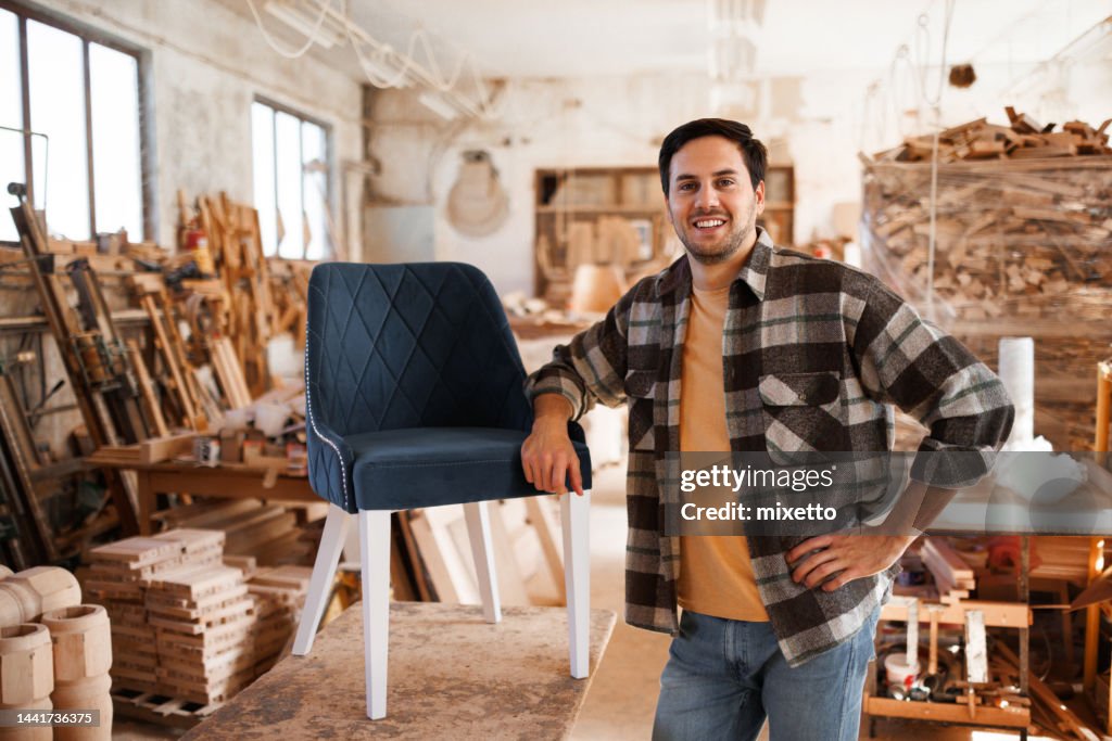 Portrait of young casually clothed chairmaker in a workshop
