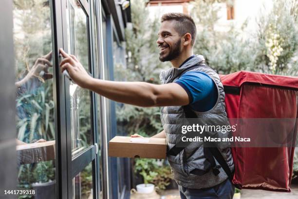 delivery man about to drop off a package - doorbell stock pictures, royalty-free photos & images