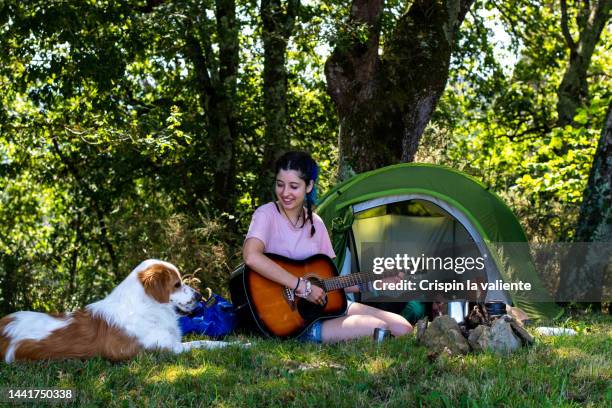 camping in nature, woman playing the guitar - acoustic guitar stock pictures, royalty-free photos & images