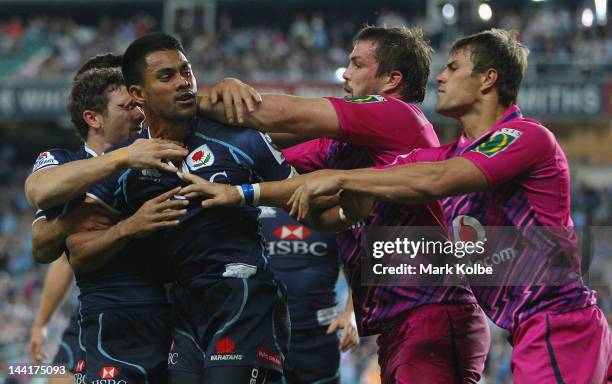 Atieli Pakalani of the Waratahs scuffles with Flip can der Merwe and JJ Engelbrecht of the Bulls after scoring a try during the round 12 Super Rugby...