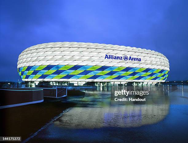 In this handout image from the Allianz Group, the Allianz Arena is illuminated with white, green and blue lights ahead of the UEFA Champions League...