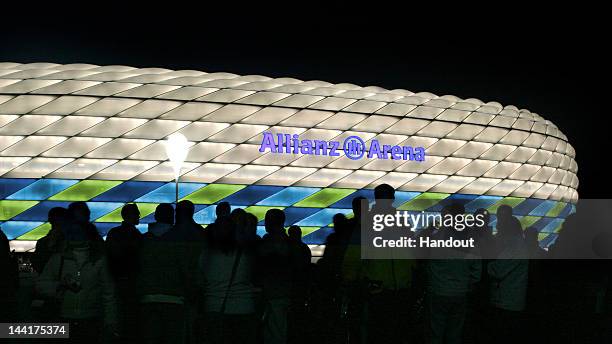 In this handout image from the Allianz Group, the Allianz Arena is illuminated with white, green and blue lights ahead of the UEFA Champions League...