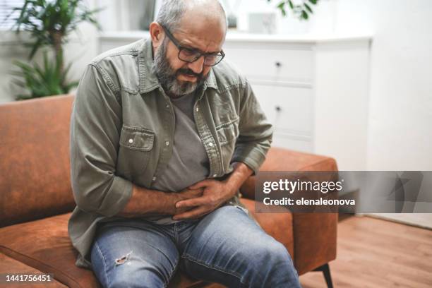 mature adult man illness - dor de barriga imagens e fotografias de stock