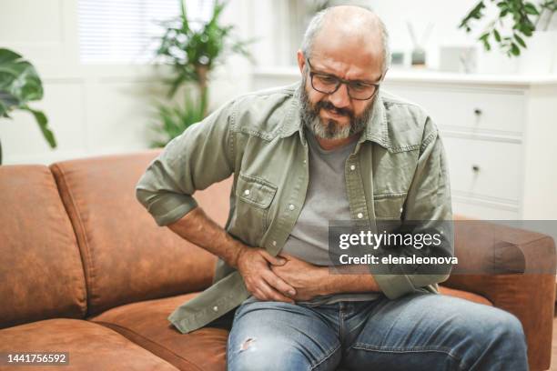 krankheit des reifen erwachsenen mannes - leistenregion stock-fotos und bilder