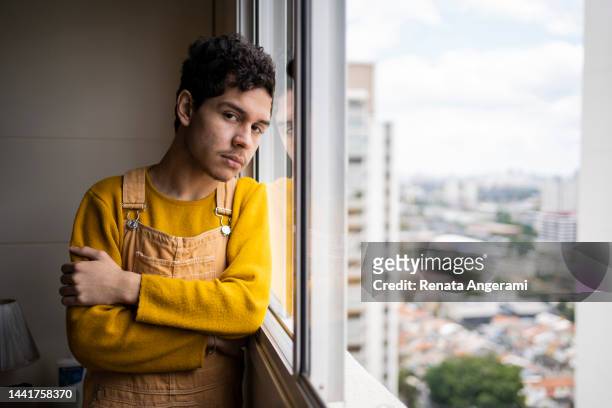 portrait of gay young man at home with depression - sad gay person stock pictures, royalty-free photos & images